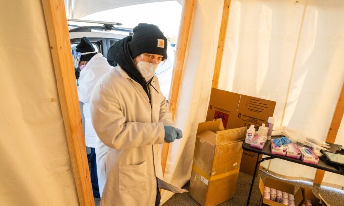 LOUISVILLE, KY - JANUARY 10: A Bluewater Diagnostic Laboratories technician works in a tent at a test at a drive-through COVID-19 testing site at Churchill Downs on January 10, 2022 in Louisville, Kentucky. Kentucky Governor Andy Beshear announced record-high COVID-19 cases in the commonwealth, with a positivity rate of more than 24%. The temporary site has the capacity to provide 3,000 tests per day in response to the sharp increase in COVID-19 cases in the US, due to the omicron variant. (Photo by Jon Cherry/Getty Images)