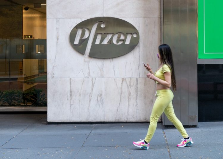 NEW YORK, NY - NOVEMBER 09: People walk by the Pfizer headquarters on November 9, 2020 in New York City. Pharmaceutical company Pfizer announced positive early results on its COVID-19 vaccine trial and has proven to be 90% effective in preventing infection of the virus. David Dee Delgado/Getty Images/AFP