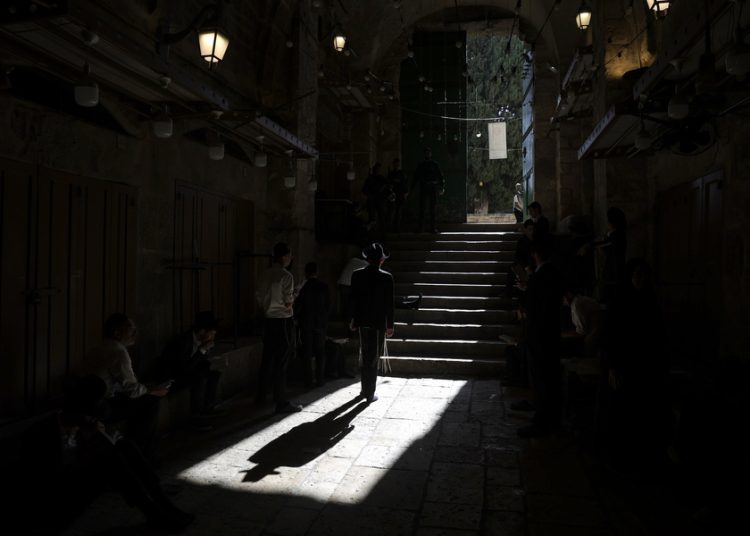 epa10770800 Orthodox Jews pray as they read from the book of Eicha (Book of Lamentations) to mark Tisha B'av, near the door leading to Al-Aqsa Mosque compound, near The Western Wall, in the Old City of Jerusalem, 27 July 2023. In Judaism, the Tisha B'Av is an annual fast day to mark the destruction of the first and the second temple by the Babylonian and the Roman Empires in Jerusalem. During Tisha B'av, Ultra-Orthodox Jews stay up all night and sleep at the Western Wall as they recite lamentations focusing on the destruction of the ancient temple, that was located on the other side of the ancient wall, on the Temple Mount. EPA/ABIR SULTAN