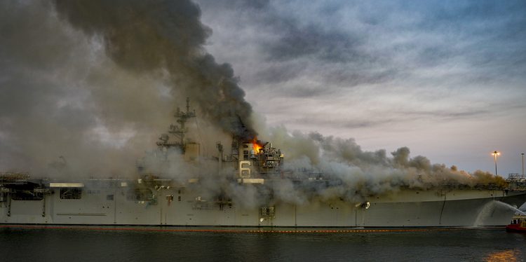epa09378790 (FILE) - A handout file photo made available by the US Navy shows a fire continuing to be fought into the evening on board USS Bonhomme Richard (LHD 6) at Naval Base San Diego, in Sand Diego, California, USA, 12 July 2020 (issued 30 July 2021). According to a statement released by the US Navy on 29 July 2021, under the Uniform Code of Military Justice (UCMJ) the US Navy has filed charges against a Navy Sailor in response to evidence found during the criminal investigation into the fire started on USS Bonhomme Richard (LHD 6) on 12 July 2020. The Sailor, whose name has not been publicly revealed and was a member of the Bonhomme Richard's crew at the time, is accused of starting the fire.  EPA/US NAVY/MC2 AUSTIN HAIST HANDOUT  HANDOUT EDITORIAL USE ONLY/NO SALES